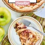 apple pie cheesecake slice and a fork on a plate and fresh apples.