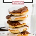five black and white cookies stacked on a plate.
