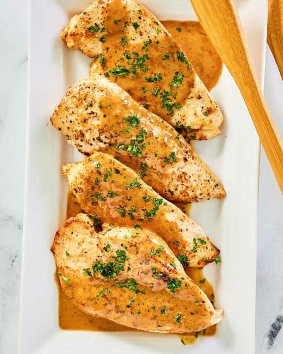 overhead view of chicken dijon and sauce on a platter.