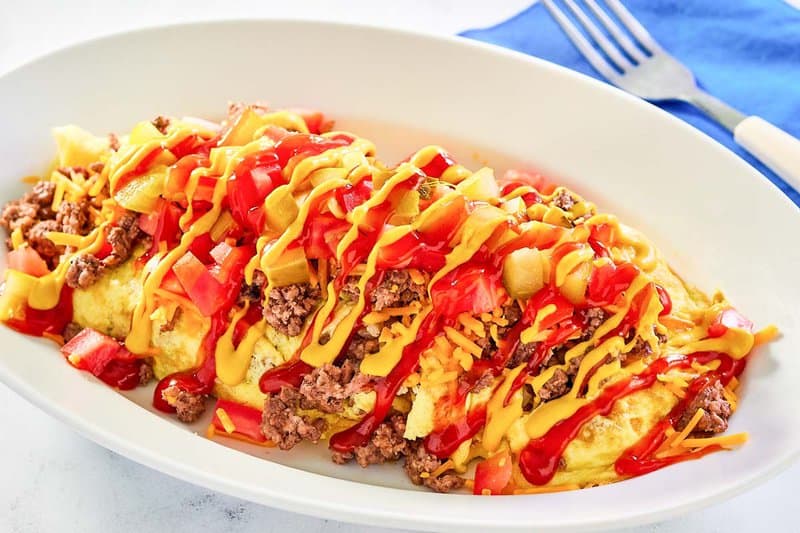 copycat IHOP cheeseburger omelette on an oval white plate.