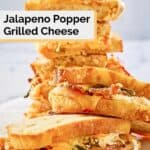 jalapeno popper grilled cheese sandwiches stacked on parchment paper.