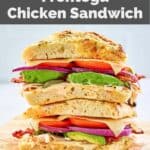 homemade Panera frontega chicken sandwich halves stacked on parchment paper.