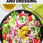 overhead view of homemade Panera Greek salad in a bowl and dressing beside it.