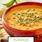 pumpkin curry soup in a bowl and limes.