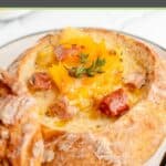 smoked sausage stew topped with cheese in a bread bowl.