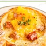 smoked sausage stew with cheese on top in a bread bowl.