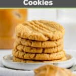 five homemade peanut butter cookies and peanut butter on a spoon.