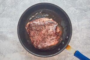 browning a beef tenderloin roast in a skillet.