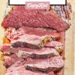 partially sliced beef tenderloin roast on a wood cutting board.