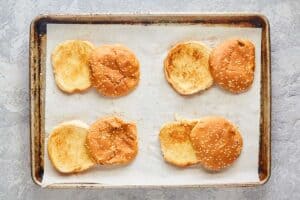 toasted sesame seed buns on a tray.