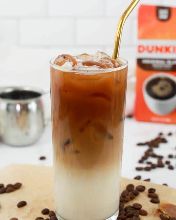 copycat Dunkin Donuts iced caramel macchiato drink with a straw.