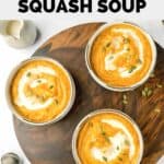 overhead view of three bowls of Panera autumn squash soup on a board.
