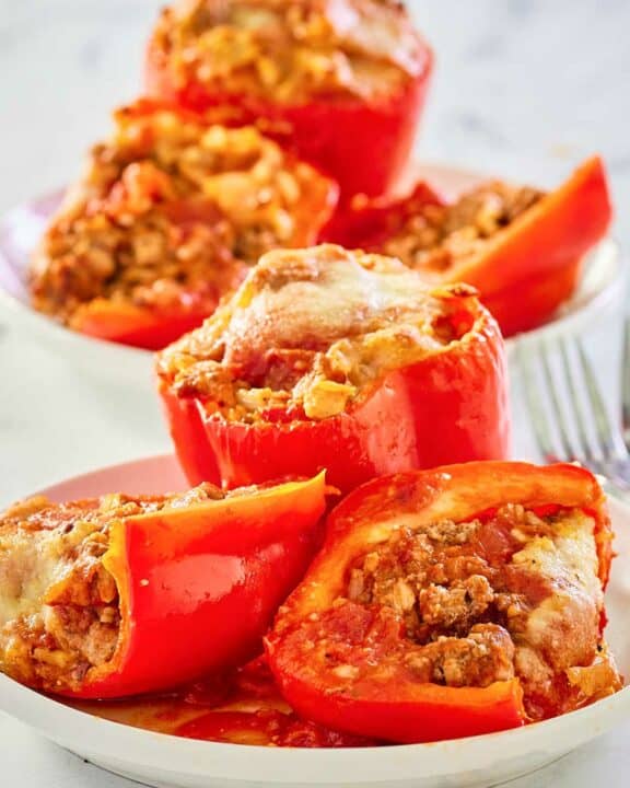 stuffed bell peppers with rice and meat on plates.