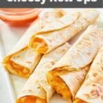 homemade Taco Bell cheesy roll ups and red sauce on a platter.
