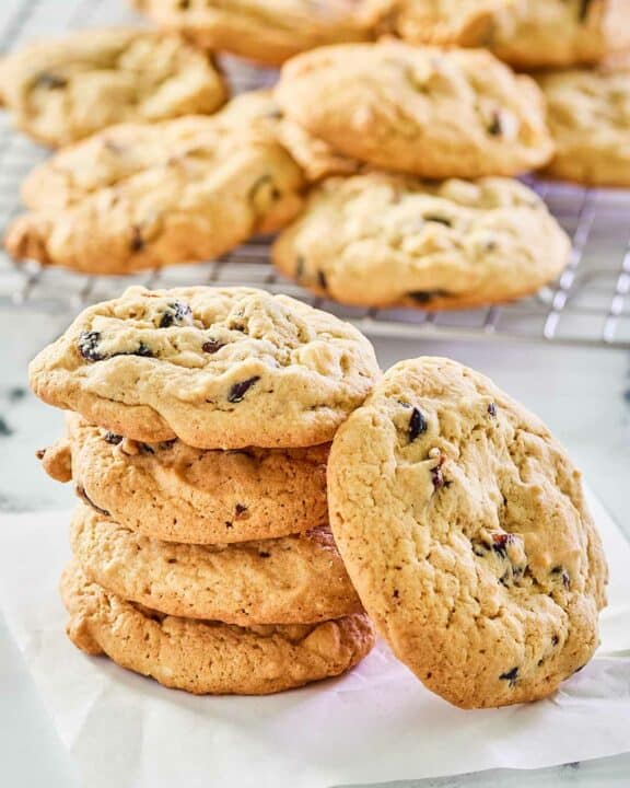 white chocolate cranberry cookies on parchment paper and a wire rack.