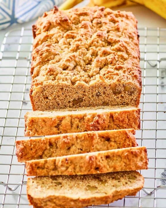 whole wheat banana nut bread slices on a wire rack.