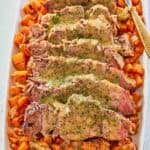 sliced Yankee pot roast with gravy and vegetables on a platter.