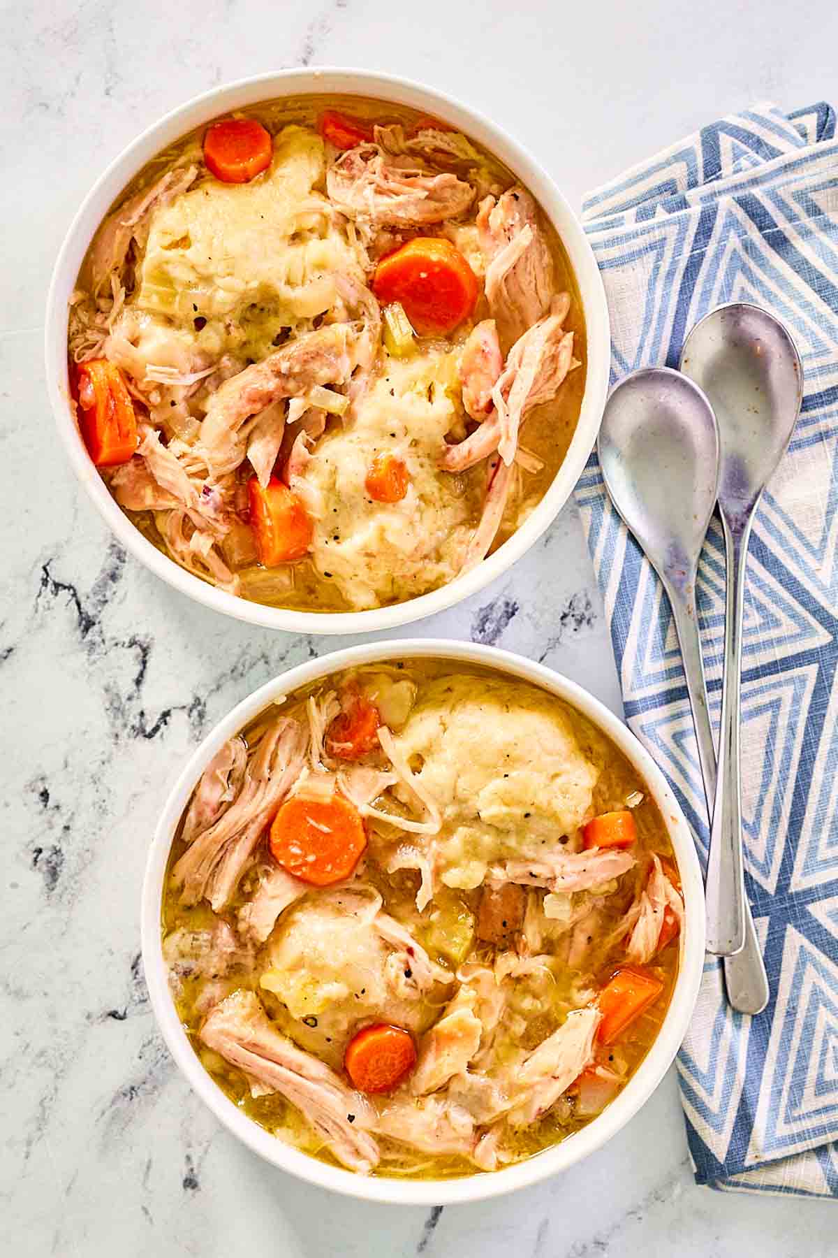 overhead view of homemade chicken and dumplings in two bowls.