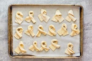 twisted pizza dough stipes on a baking sheet.