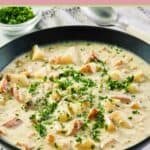 clam chowder garnished with parsley in a black bowl.