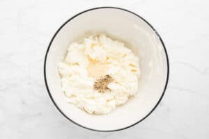 goat cheese, cream cheese, and seasonings in a bowl.