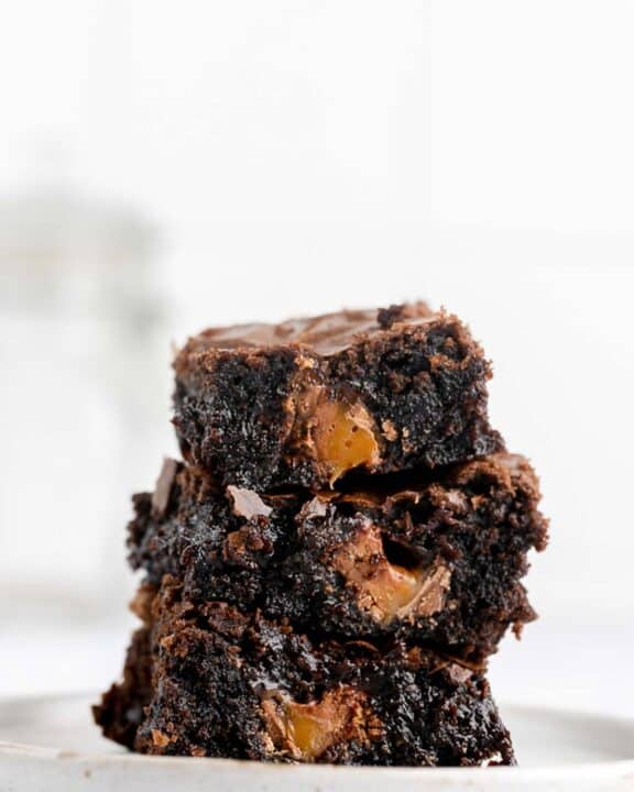 three milky way brownies in a stack on a plate.