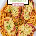 overhead view of homemade Olive Garden chicken parmigiana and pasta on a platter.