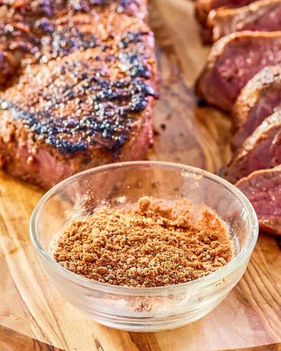 bowl of copycat Outback steak seasoning and two steaks.
