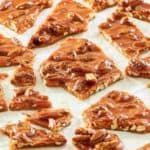 pecan brittle pieces scattered on parchment.