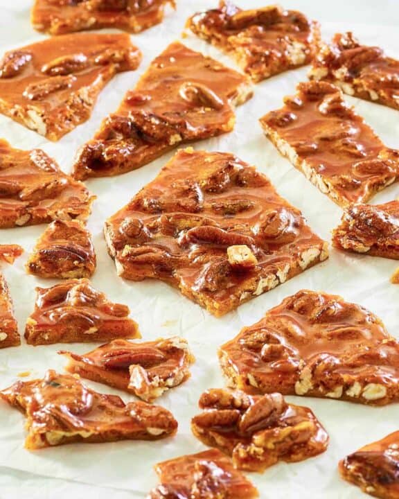 pecan brittle pieces scattered on parchment.