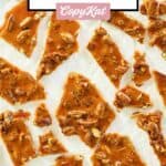 overhead view of pieces of pecan brittle scattered on parchment.