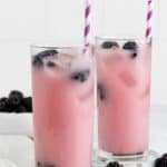 homemade Starbucks violet drink in two glasses and blackberries.