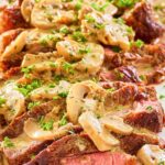 steak marsala with sauce on a white platter.
