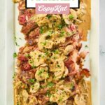 overhead view of steak marsala on a rectangular white platter.