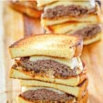 copycat Whataburger patty melt sandwiches on a wood board.