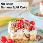 banana split cake slice on a plate and a banana beside it.