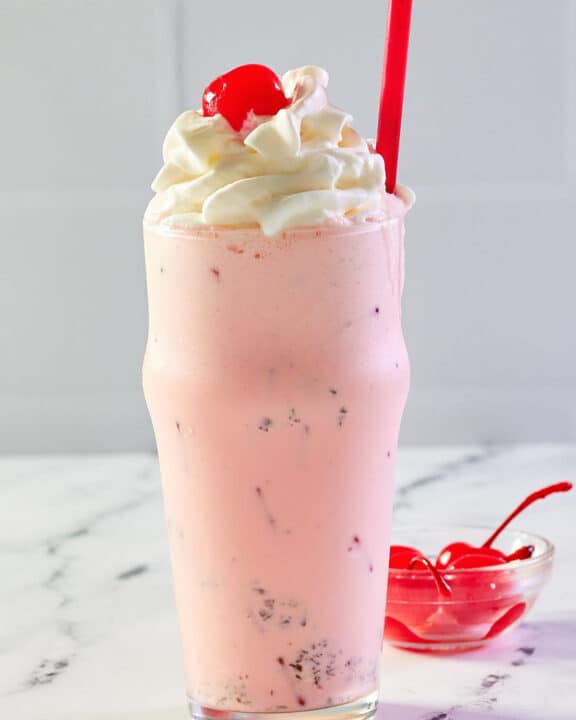 copycat Chick Fil A peppermint milkshake and a bowl of cherries..