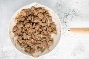 browned ground beef and onions in a skillet.
