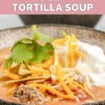 bowl of homemade Luby's tortilla soup with cheese and sour cream on top.
