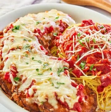 copycat Olive Garden eggplant parmigiana, pasta, and marinara on a platter.