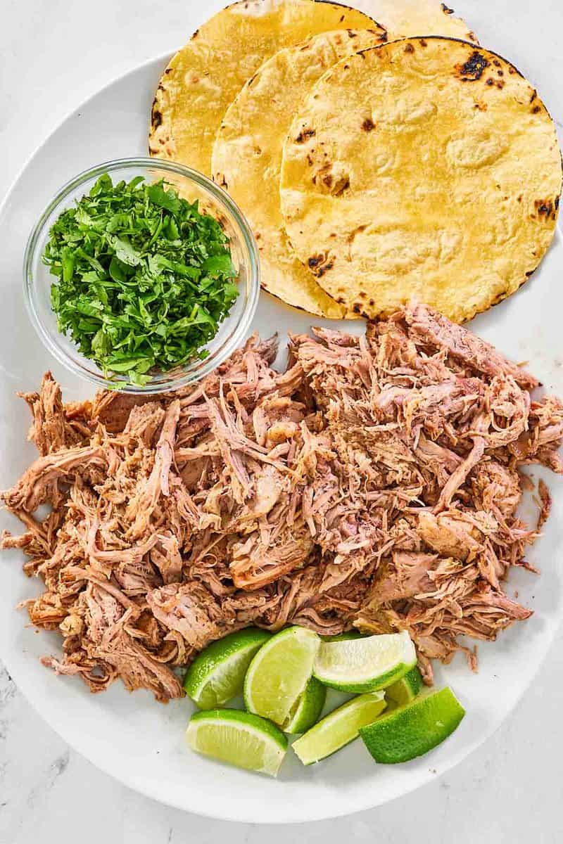 overhead view of shredded roasted pork shoulder on a platter.