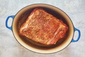 chipotle seasoned pork shoulder in a Dutch oven.
