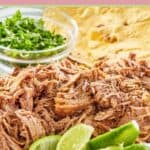 pulled pork shoulder, lime wedges, cilantro, and tortillas.