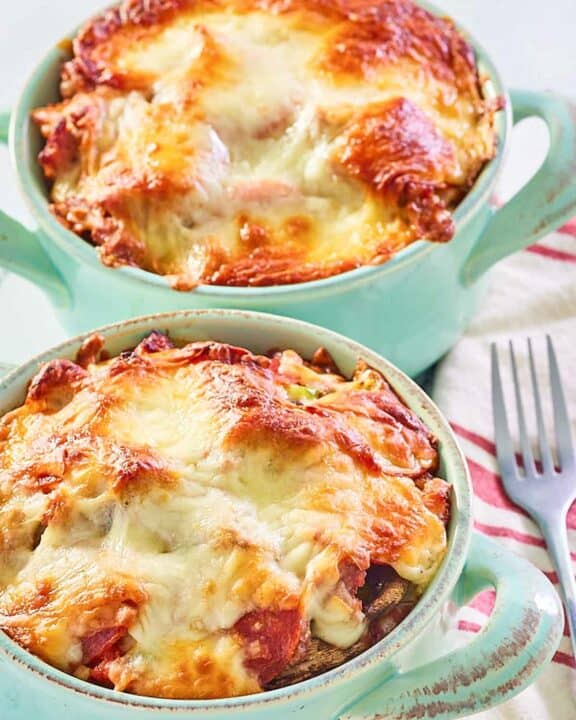 two pizza bowls with melted mozzarella cheese on top.