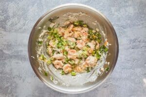 adding sauteed vegetables to shrimp mixture.