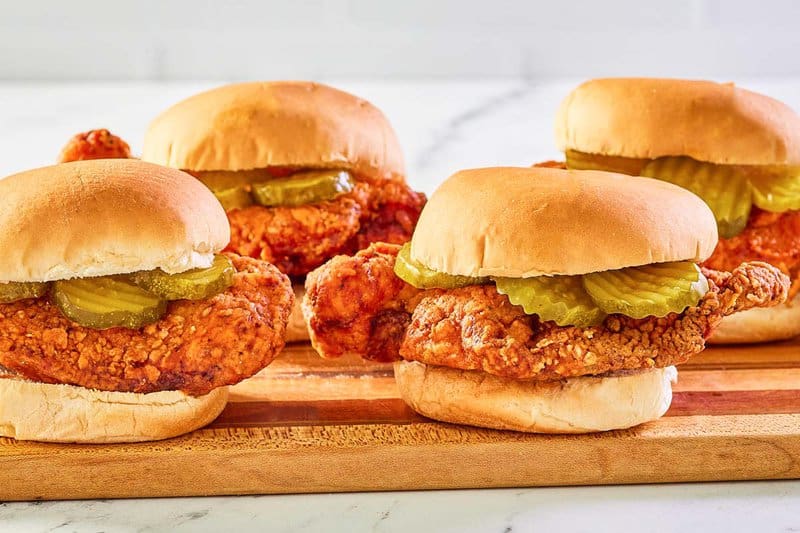 copycat wingstop buffalo chicken sandwiches on a wood board.