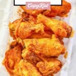 overhead view of homemade Wingstop Cajun wings on parchment paper in a basket.