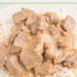 homemade traditional beef stroganoff over rice on a plate.