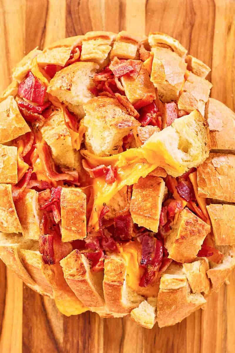 overhead view of cheesy pull apart bread on a wood board.