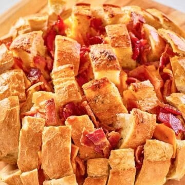 cheesy pull apart bread on a wood board.